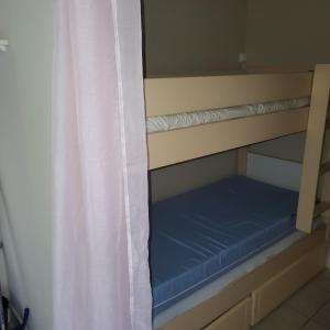a bunk bed in a room with a curtain at Heliotel Marine plages piscines tennis terrasse jardin in Saint-Laurent-du-Var +21 photos