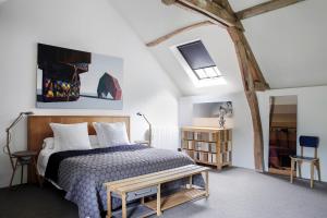 - une chambre avec un lit et un banc dans l'établissement Chateau De La Resle - Design Hotels, à Montigny-la-Resle
