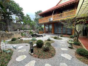 a garden with rocks and plants in front of a building at Villa KimAnh in Sóc Sơn +22 photos