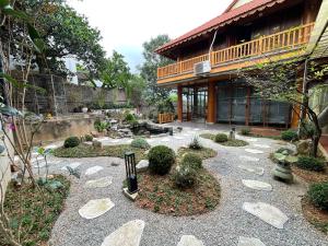 a garden with rocks and plants in front of a building at Villa KimAnh in Sóc Sơn