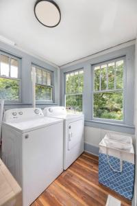 a laundry room with a washer and dryer and windows at Century-Old Remodeled Splendor in Salisbury +65 photos