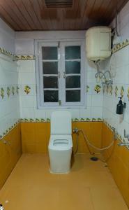 a bathroom with a toilet and a window in it at Trippers CastleWoods in Darjeeling +17 photos
