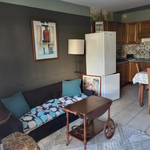 a living room with a couch with a table and a refrigerator at Heliotel Marine plages piscines tennis terrasse jardin in Saint-Laurent-du-Var