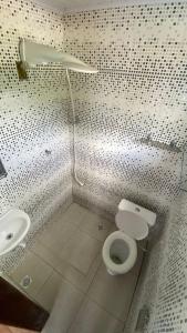 a bathroom with a toilet and a sink at Família Ebeneze in Santa Maria Madalena