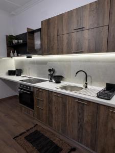 a kitchen with wooden cabinets and a sink at MP House Kassandrino Halkidiki in Kassandrinón +14 photos