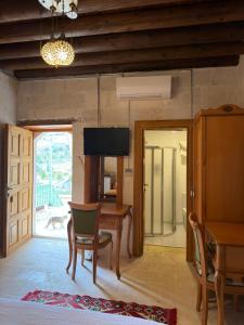 a living room with a table and a television at Yusuf Çavuş Konağı in Halfeti