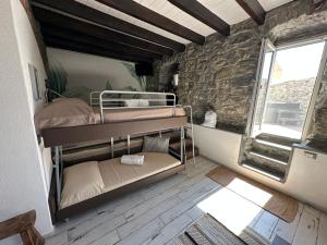 a bedroom with bunk beds in a room with a stone wall at Madüneta 5 Terre in Corniglia +145 photos