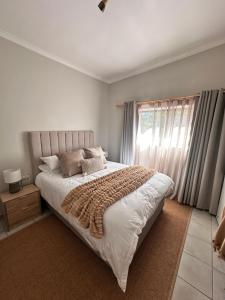 a bedroom with a large bed and a window at 95 on Acacia in Helderberg