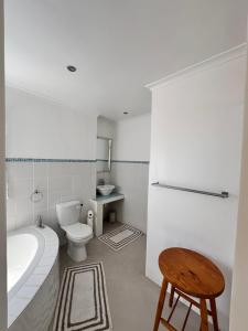 a bathroom with a tub and a toilet and a sink at 95 on Acacia in Helderberg