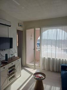 a living room with a large window with a view of the ocean at Le goéland in Port Leucate
