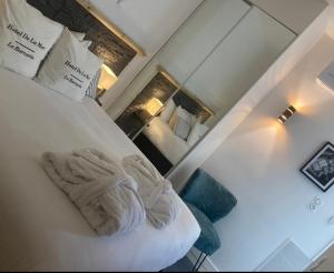 a room with a bed with a pillow and a mirror at Hôtel de la Mer - Barcarès, à 100 m de la plage in Le Barcarès