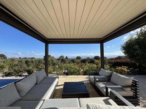 a screened in porch with couches and a table at MayaElisa Villa with Heated Pool, By Hellocrete in Vamos