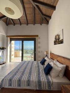 a bedroom with a large bed with blue pillows at MayaElisa Villa with Heated Pool, By Hellocrete in Vamos +40 photos