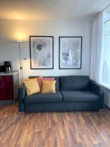 a blue couch in a living room with wood floors at Traumblick auf‘s Meer in Sierksdorf