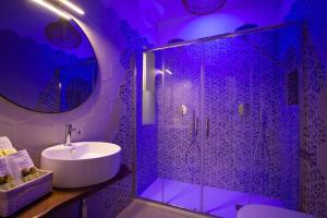 a bathroom with a sink and a shower with purple lighting at Le Dune Luxury Rooms in Vieste +67 photos