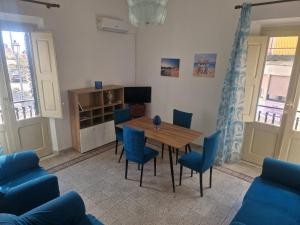 a dining room with a table and blue chairs at Brezza Marina in Bova Marina