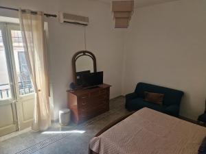 a bedroom with a bed and a tv and a chair at Brezza Marina in Bova Marina
