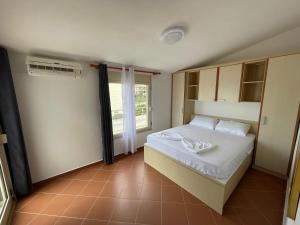 a small bedroom with a bed and a window at Sea Gate Apartments in Sarandë