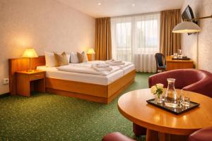 a hotel room with a bed and a table at Lázeňský hotel Pyramida in Františkovy Lázně +39 photos