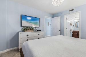 a bedroom with a bed and a flat screen tv at Pelican Beach Resort 504 in Destin