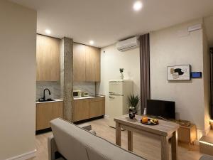 a living room with a table and a kitchen at Bianca Suites III in Bormujos