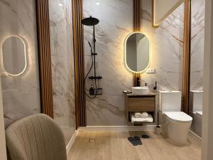 a bathroom with a toilet and two mirrors at Bianca Suites III in Bormujos
