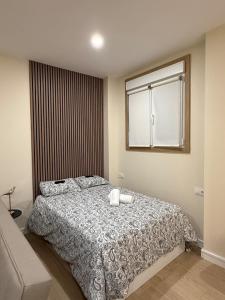 a bedroom with a bed with two pillows and a window at Bianca Suites III in Bormujos