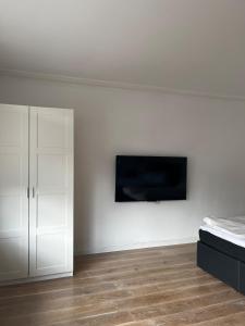 a bedroom with a bed and a tv on a wall at Ferienwohnung Fatlume 2 in Bad Honnef am Rhein