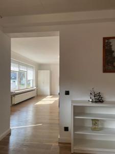 an empty living room with white walls and wood floors at Ferienwohnung Fatlume 2 in Bad Honnef am Rhein