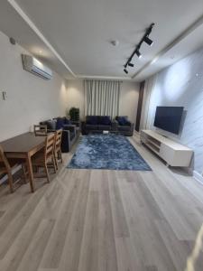 a living room with a couch and a tv and a table at درة رواق للشقق المخدومة - Durrat Rwaq Serviced Apartments in Riyadh