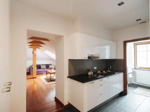 a kitchen with white cabinets and a black counter top at Pensjonat Maria 2 in Szczyrk