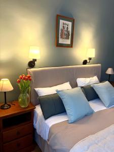 a bedroom with a bed with blue and white pillows at Hotel de la Sologne in Beaugency