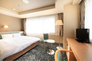 um quarto de hotel com uma cama e uma televisão em Hotel Premium Green Hills em Sendai