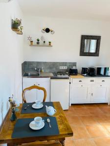 a small kitchen with a wooden table and a tableablish at Studio Chez Joelle in Carpentras