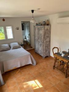 a bedroom with a bed and a wooden table at Studio Chez Joelle in Carpentras