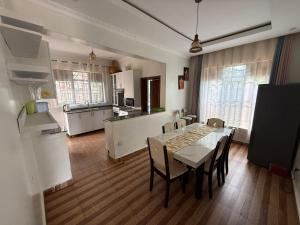 a kitchen and dining room with a table and chairs at Eden house in Kigali