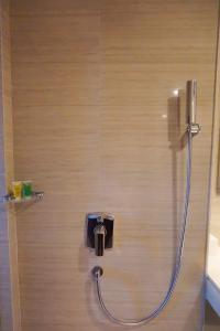 a shower with a hose attached to a wall at Platinum Adisucipto Hotel & Conference Center in Yogyakarta