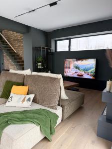 a living room with a couch and a flat screen tv at Nordic Star Chalet in Fundata