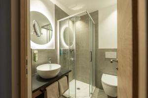 a bathroom with a sink and a shower and a toilet at Hotel Mirabell in Campo Tures