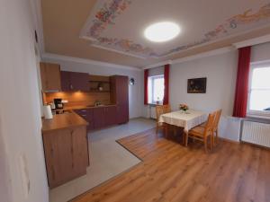 a kitchen and dining room with a table and chairs at Pension Alter Wirt in Enkering