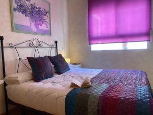 a bedroom with a bed with a book on it at Apartamento La Plazuela in Almagro