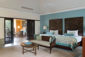 a bedroom with a bed and a couch and a table at Cape Weligama in Weligama