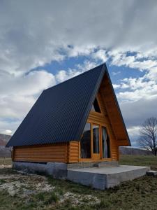 a small log cabin with a black roof at Diva House in Nikšić