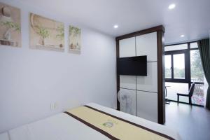 a bedroom with a bed and a tv and a mirror at Tam Coc Green Haven Retreat in Ninh Binh