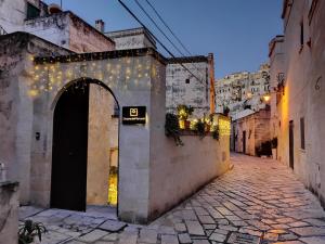 an alley with lights on the side of a building at Dimore dei Mercanti in Matera