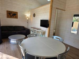 a living room with two tables and a couch at Maisonnette privative Bassin Arcachon in Le Teich