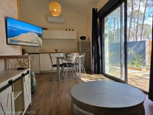 a kitchen and dining room with a table and a tv at Maisonnette privative Bassin Arcachon in Le Teich