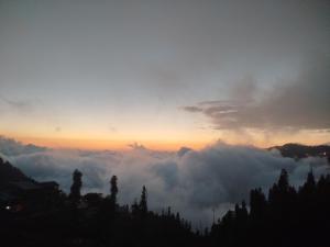 a view of the sun rising above the clouds at Hotel Crown Palace in Dunga Gali