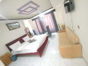 a room with a bed and a couch and a television at Hotel Crown Palace in Dunga Gali