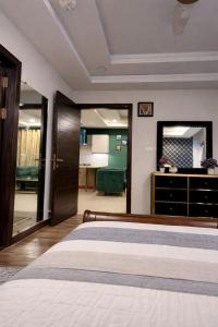 a bedroom with a bed and a dresser and a mirror at SmartStay Residences in Rawalpindi